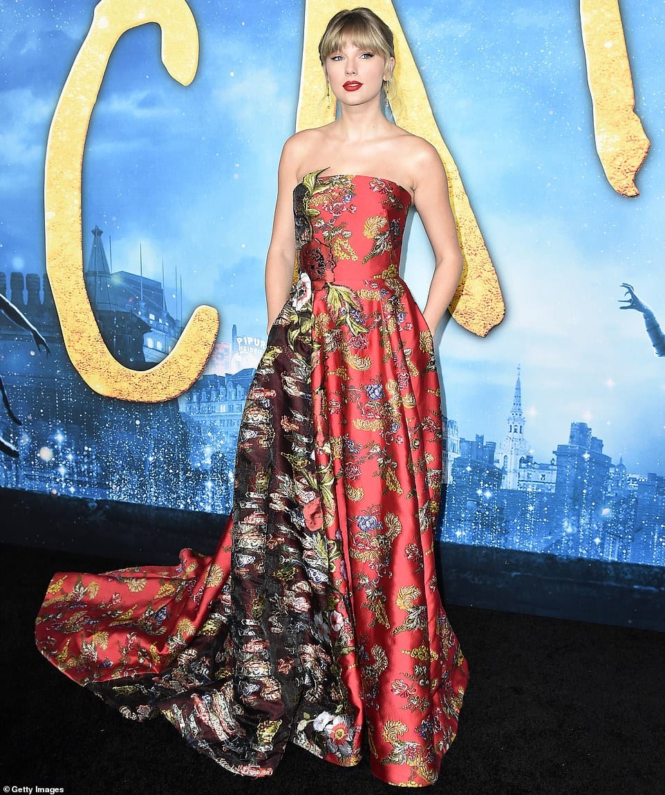 Taylor Swift is an absolute vision in a red floral gown with crimson lipstick as she leads the stars at the premiere of the film Cats in New York City