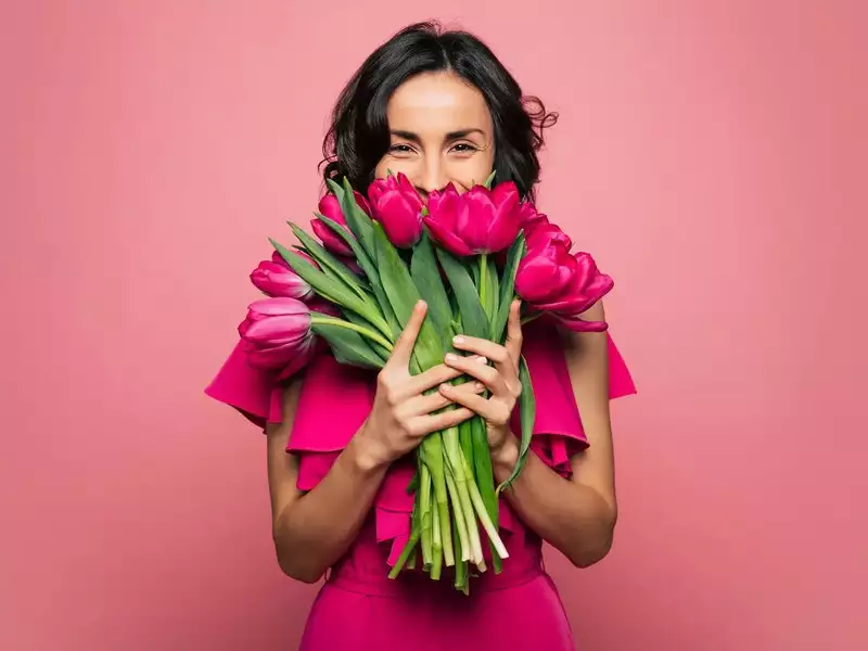 women holding hot pink tulips
