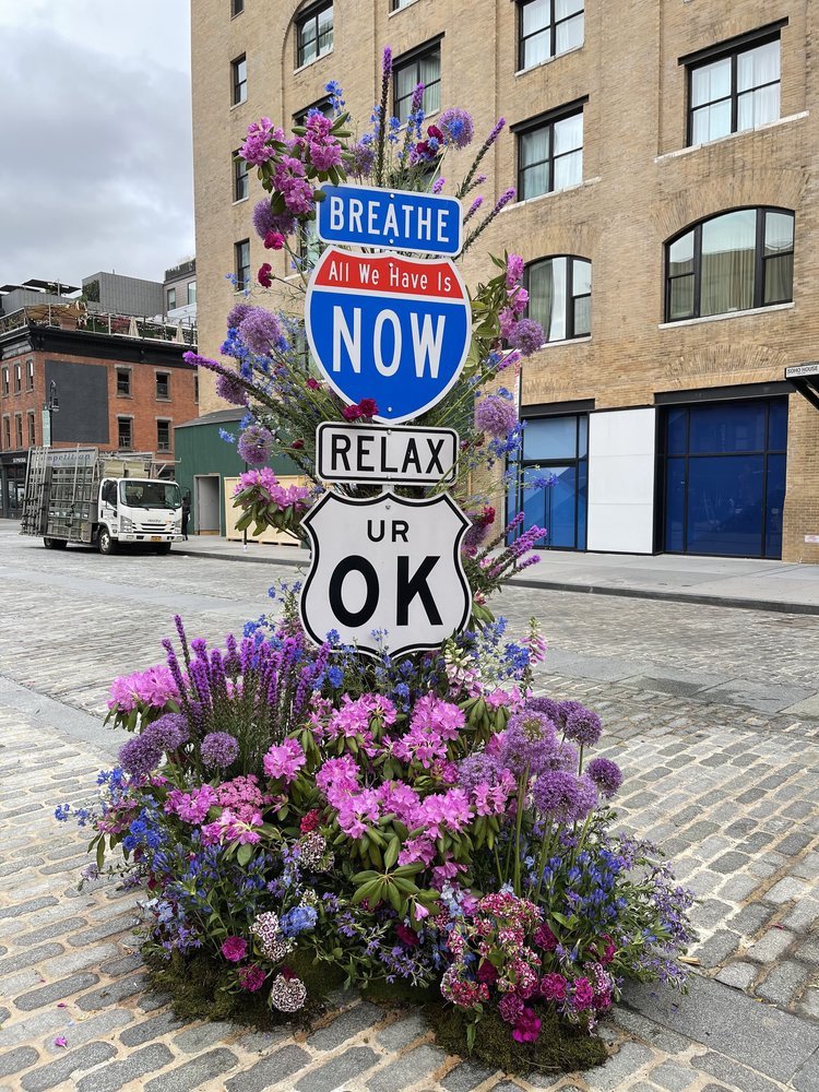 street sign with flowers all around