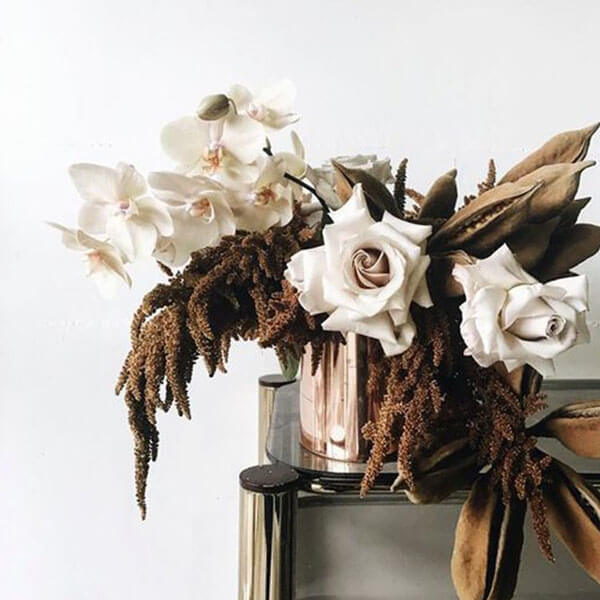 BURNT BLOOMS  Amaranth with dried pods, orchids, and roses in a gold vase. (via the LANE)
